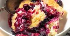 blueberry cobbler in a white bowl with a spoon on the side, ready to be eaten