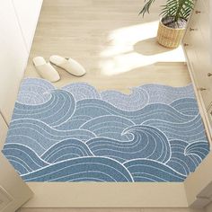 an aerial view of a bathroom with blue waves on the floor and white cupboards