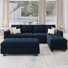 a living room with blue couches and pillows on the floor next to a window