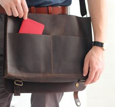 a man holding a brown leather briefcase with a red card in it's pocket