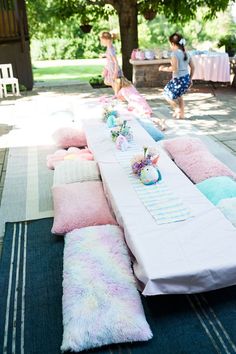 a long table covered in pink and blue pillows