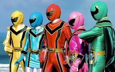 the power rangers are standing in front of the ocean with their backs to the camera