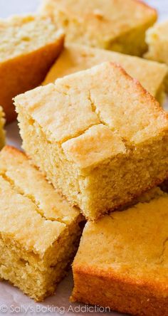 several pieces of cornbread sitting on top of a cutting board next to a knife