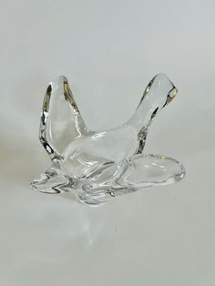 a glass bird figurine sitting on top of a white tablecloth covered floor