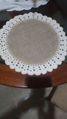 a white doily sitting on top of a wooden table