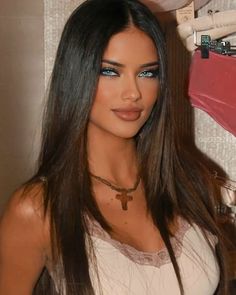 a woman with long brown hair and blue eyes posing for the camera in front of a mirror