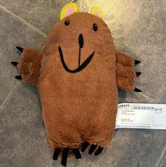 a brown stuffed animal with horns and eyes on it's back laying on the floor