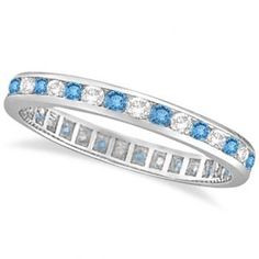 a white gold ring with blue topaz and channeled diamonds on the sides, set in