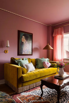 a living room filled with furniture and a painting on the wall next to a window