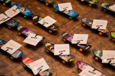 many skateboards are lined up on the table with name tags attached to their boards