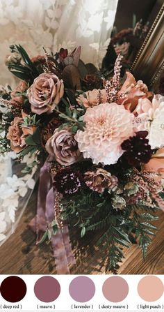 a bouquet of flowers sitting on top of a wooden table next to a framed mirror