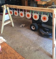 an assembly area with several different types of discs hanging from hooks on the ceiling and wheels parked in front of it