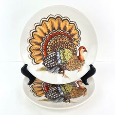 two turkey plates sitting on top of each other in front of a white background with black handles