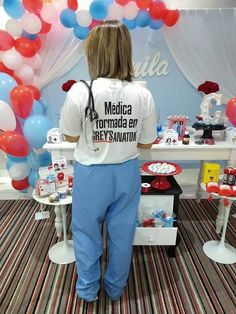 a woman standing in front of a table with balloons