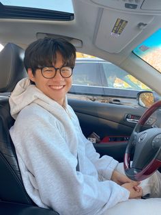 a woman sitting in the driver's seat of a car