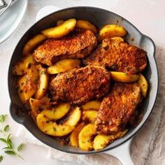 a pan filled with meat and potatoes on top of a table