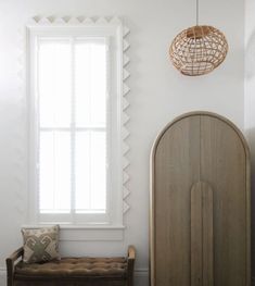 a bed sitting under a window next to a wooden headboard and foot board in a bedroom