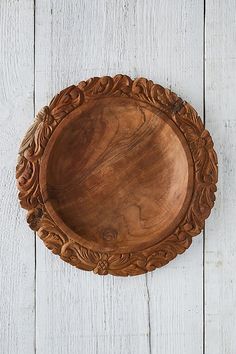 an old wooden plate on a white wood table