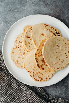 four tortillas on a white plate