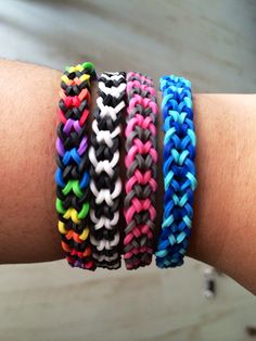 four different colored bracelets on someone's arm