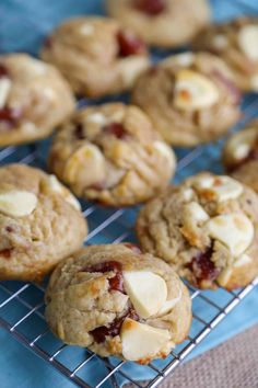 a cooling rack filled with cookies and cranberry toppings on top of a blue table cloth