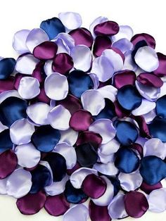 a pile of purple and blue flowers on a white surface