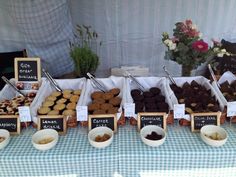 there are many different types of pastries on display at the table with price tags