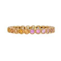 a yellow gold ring with pink and orange sapphires on it's sides, set against a white background