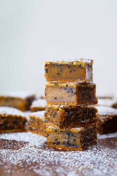 four pieces of cake sitting on top of a wooden table covered in powdered sugar