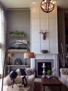 a living room filled with furniture and a fire place in front of a wall mounted deer head