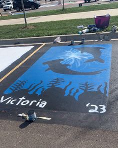 a blue and black painted parking lot with the word victoria painted on it's side