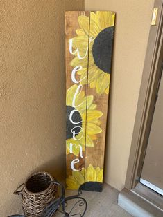 a wooden sign with the words welcome to us and sunflowers painted on it