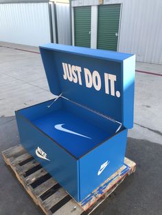 a blue box with the words just do it on it sitting on top of pallets