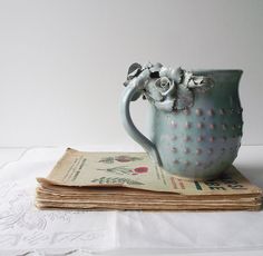 a blue vase sitting on top of an old book