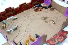 an open cardboard box with various toy animals on the inside and writing on the outside