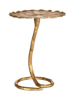 a gold colored table with a flower design on it's top and a snake like base