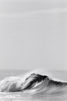 a black and white photo of a wave in the ocean