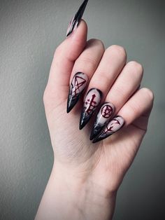 a woman's hand with black and white nail art on it, holding up her nails