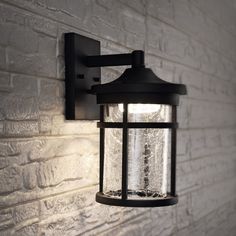 an outdoor light on the side of a brick wall