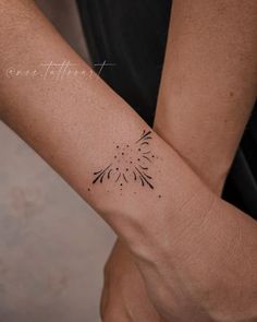 a woman's arm with a tattoo on it that has an image of a flower