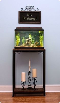 there is a fish tank and two candles in front of the sign that says no fishing