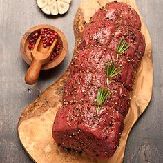 a piece of meat sitting on top of a wooden cutting board