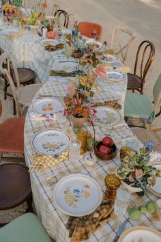 a table set up with plates and flowers on it