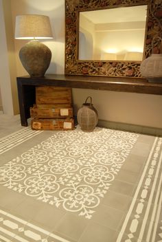 a room with a rug, mirror and vase on the floor