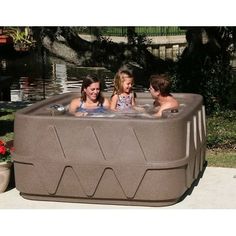 three children are sitting in an outdoor hot tub