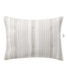 a white and grey striped pillow on a white background with an arrow pointing to the left