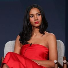 a woman in a red dress sitting on a chair