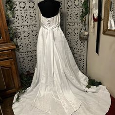 a white wedding dress on display in front of a mirror