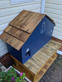 a dog house made out of pallets with a cat door on the top and side