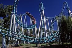 the roller coaster at six flags amusement park is blue and gray with red people on it